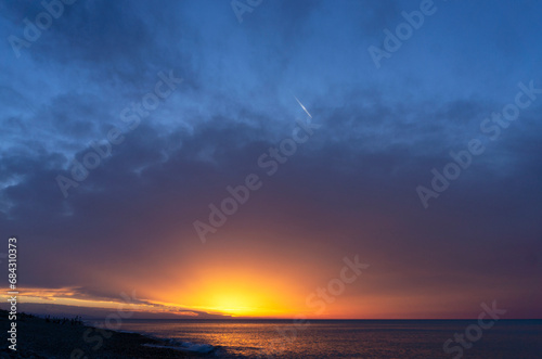 Sunset sky over the sea. Yellow, orange, red, purple and blue gradient.