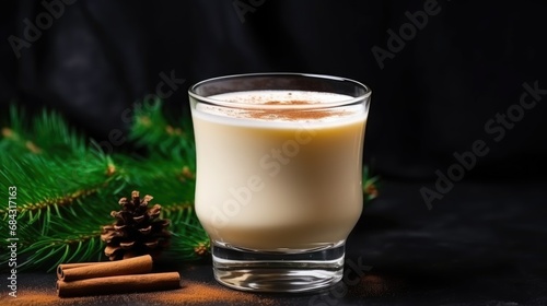 Christmas Hot Drink. Eggnog with Cinnamon in Glass with Branches Fir Tree on Dark Background