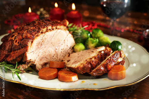 Cuadro en lienzo Christmas ham or roast pork with crispy fat crust, served with vegetables on a d