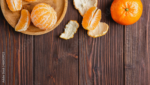 Tangerines on a plate on a brown wooden table.