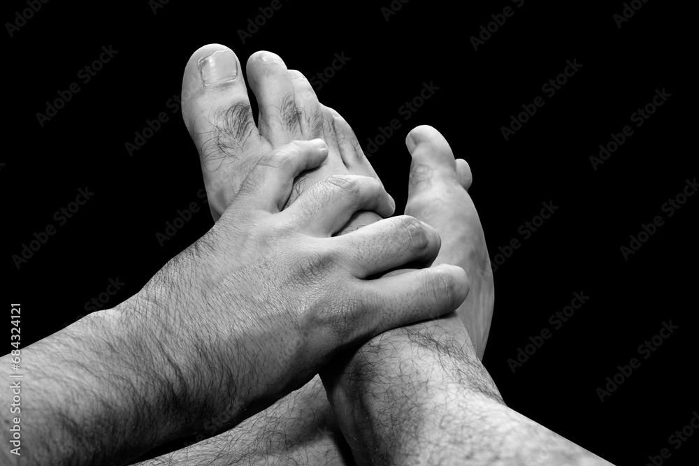 Fototapeta premium Male hand holding male feet