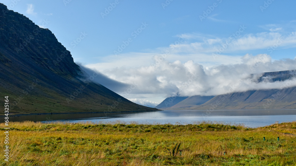 Fototapeta premium The late day sun shines on a fjord in northwest Iceland.