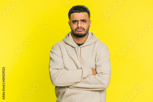 Mad sad Indian young man depressed in stress tension problems feels horror hopelessness fear panic surprise shock expresses gestures rage. Handsome hindu guy isolated on yellow studio background