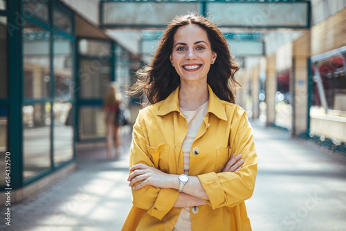 Portrait of a confident young woman standing at the city. Beautiful female in casuals looking at camera. Happy young woman on street. Latin stylish girl smiling while standing on street.