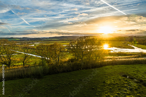 Sunset over Wetlands and Marshes in RSPB Exminster and Powderham Marshe from a drone, Exeter, Devon, England photo