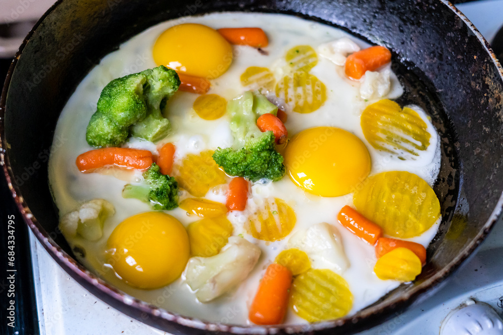 Composition with fried eggs and vegetables in a pan Composition with fried eggs and vegetables in a pan