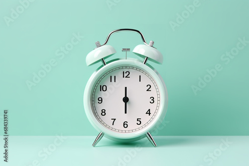 White alarm clock on mint green background
