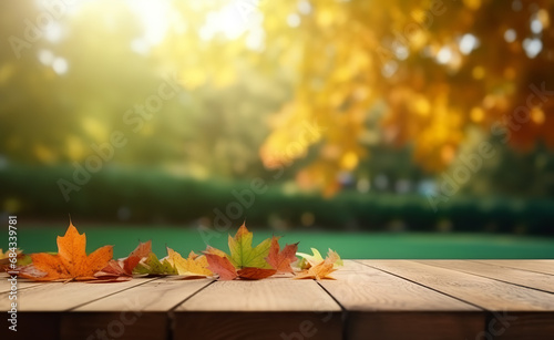 Wood table top with autumn leaves in the garden on the background