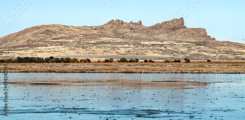 Panorama of rock formations rising above Tule Lake in California, USA