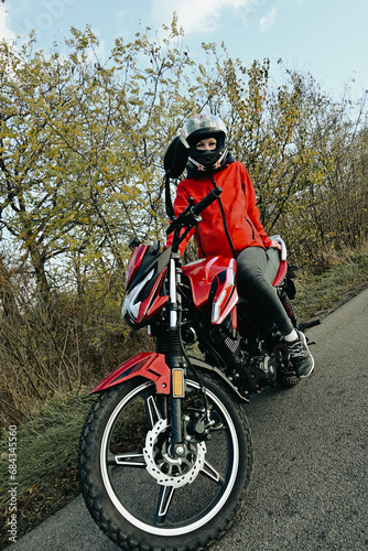 Fototapeta Naklejka Na Ścianę i Meble -  biker girl in red. red motorcycle.