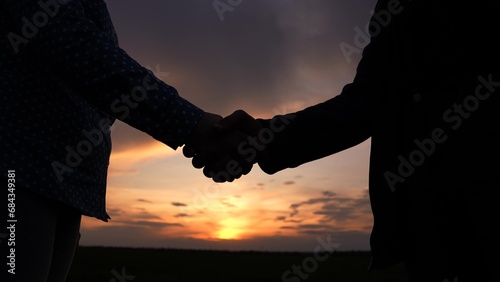 Business through handshake. Hand silhouette. Business people shake hands outdoor. Two businessmen shaking hands signed contract. Conclusion of deal, Handshake agreed. Greetings, sky. Trust partner