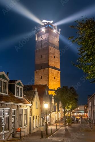 Lighthouse Brandaris at Terschelling with historic street and bright light beam photo