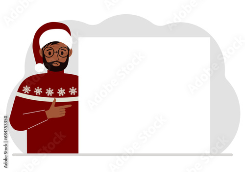 A man in a red sweater near a large white sheet. Advertising, invitation, discount for Christmas or New Year.