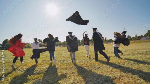 Happy graduates run in and take off their robes. The concept of graduation.