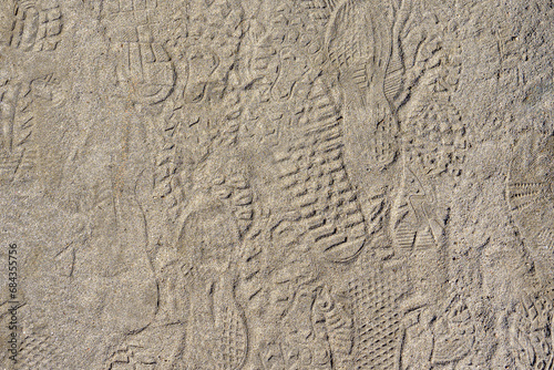 Dirt sand ground with shoe footprints. Background photo texture. © TomWindeknecht