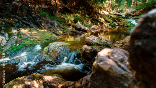 Flowing water in waterfall between rocky stream in the mountains
