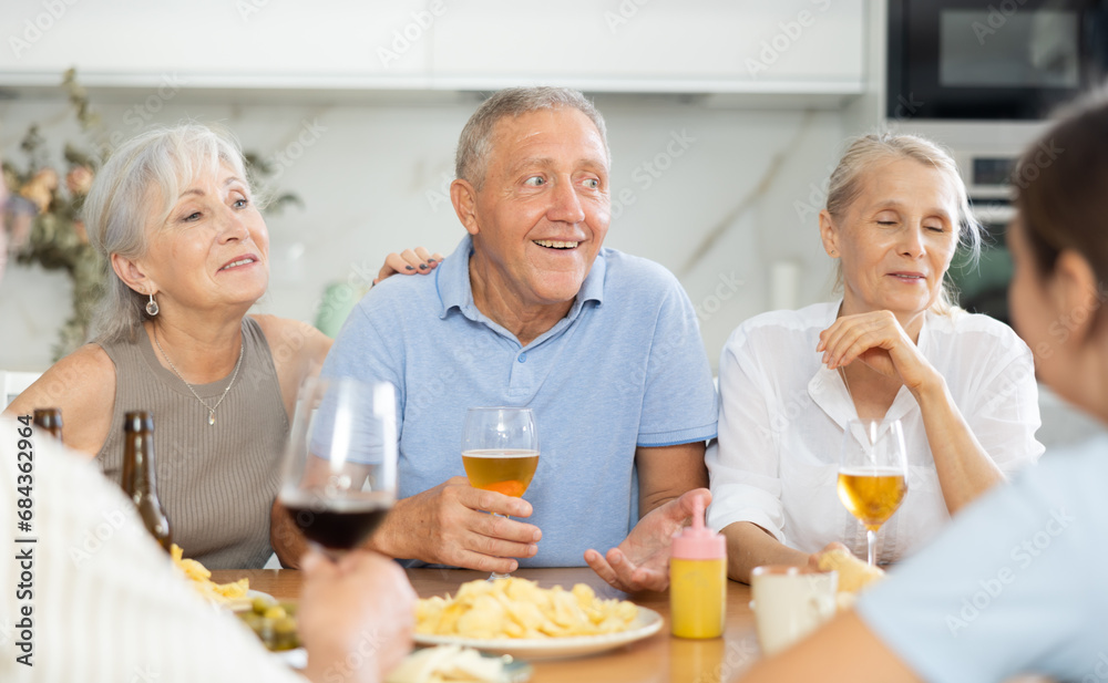 Happy seniors chatting at dinner table. Concept of happy life together in a nursing home