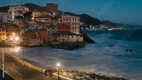 Long exposure Panorama of the little Italian town Boccadasse in the evening. Dramatic see and clear blue sky in the winter.