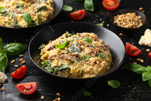 Creamy spaghetti squash pasta with parmesan cheese and sun dried tomato sauce served with pine nuts and basil.