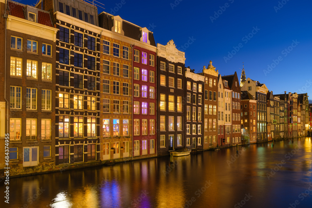 Amsterdam, Netherlands. View of houses during evening. The famous Dutch canals. A cityscape in the evening. Postcard, background, wallpaper.
