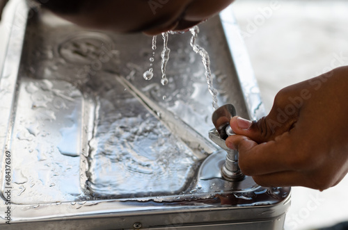 Hand pressing a water fountain button. quench your thirst.