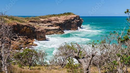 Australian coast, high cliffs on the seashore, seaside landscape with blue water, view from the cliff on a sunny summer day.