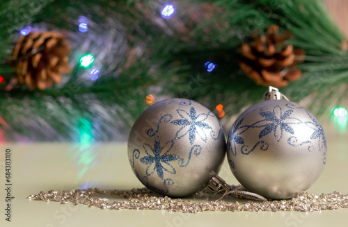 New Year's balls in close-up on the background of a Christmas tree branch with cones