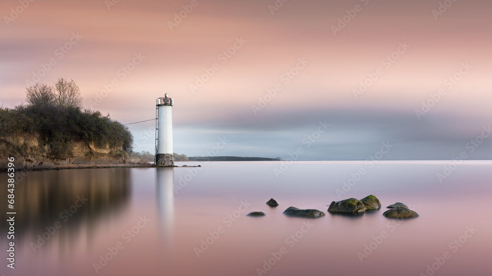 Farbenfroher Sonnenuntergang hinter dem Leuchtturm Maltzien in der Ostsee auf Rügen
