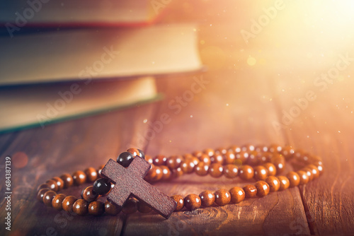 religious rosaries on the background of books with sacred teachings and magical light. the concept of religion. place for text photo