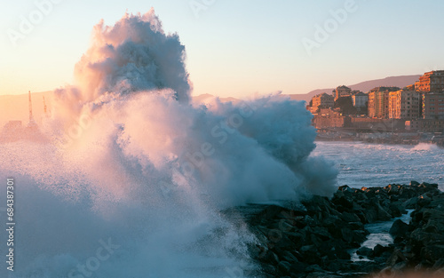 Powerful wawes on the coast of Italian city Genova. Dramatic stormy sea at the sunset.