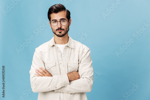 Portrait of a stylish man smile with teeth in glasses for farsightedness and myopia, on a blue background in a white T-shirt, fashionable clothing style, space space