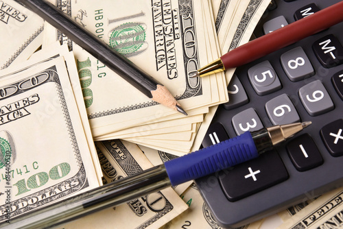 Paper money dollar banknotes, pens, pencil and calculator