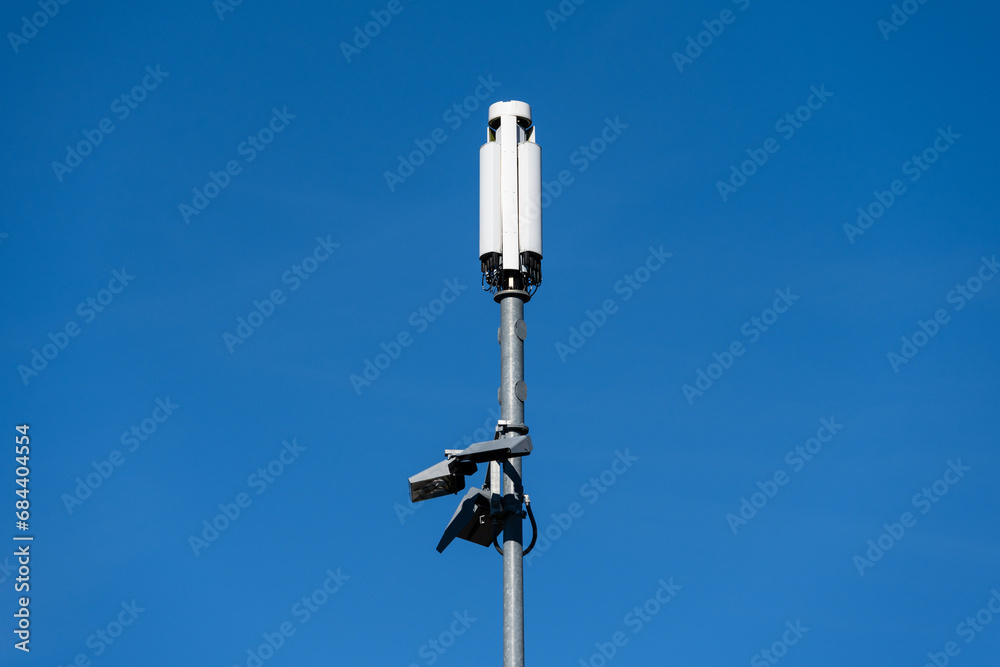 Mobile technology communication cell tower against a sunny blue sky, narrow metal monopole and small white panel antenna
Mobile technology communication cell tower against a sunny blue sky, narrow metal monopole and small white panel antenna