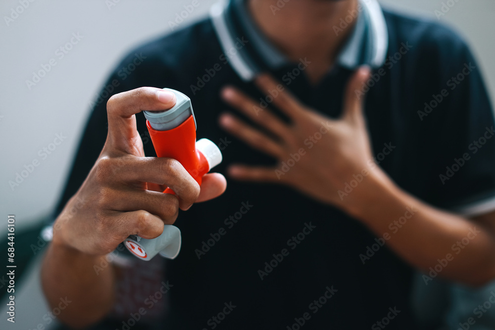 Man holding asthma inhaler for relief asthma attack. - obrazy, fototapety, plakaty 