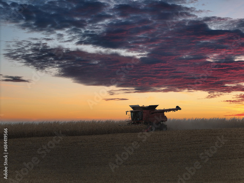 Combine working after sunset to harvest corn