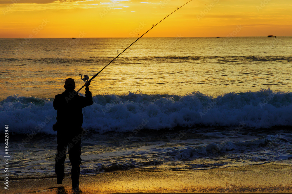 An early morning fisherman catching fish ocean at sunrise An early morning fisherman catching fish ocean at sunrise