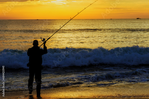 An early morning fisherman catching fish ocean at sunrise