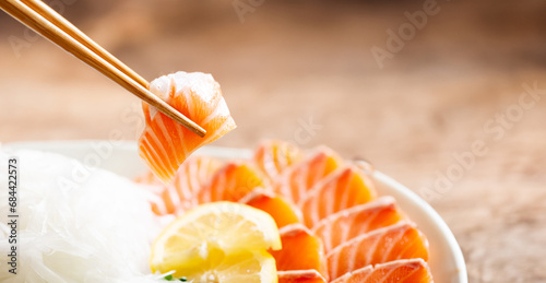 pick up raw salmon with chopsticks photo