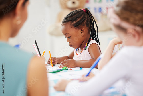 African, kid and pencil for drawing in classroom for learning, education and development of motor skills. Little girl, student on learner with serious, determination and look for creative activity photo