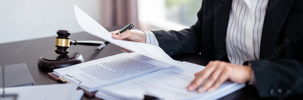 Obraz Lawyer businesswoman holding document to reading lawsuit and checking about financial business data while analysis about legislation agreement and terms data of business contract in law firm