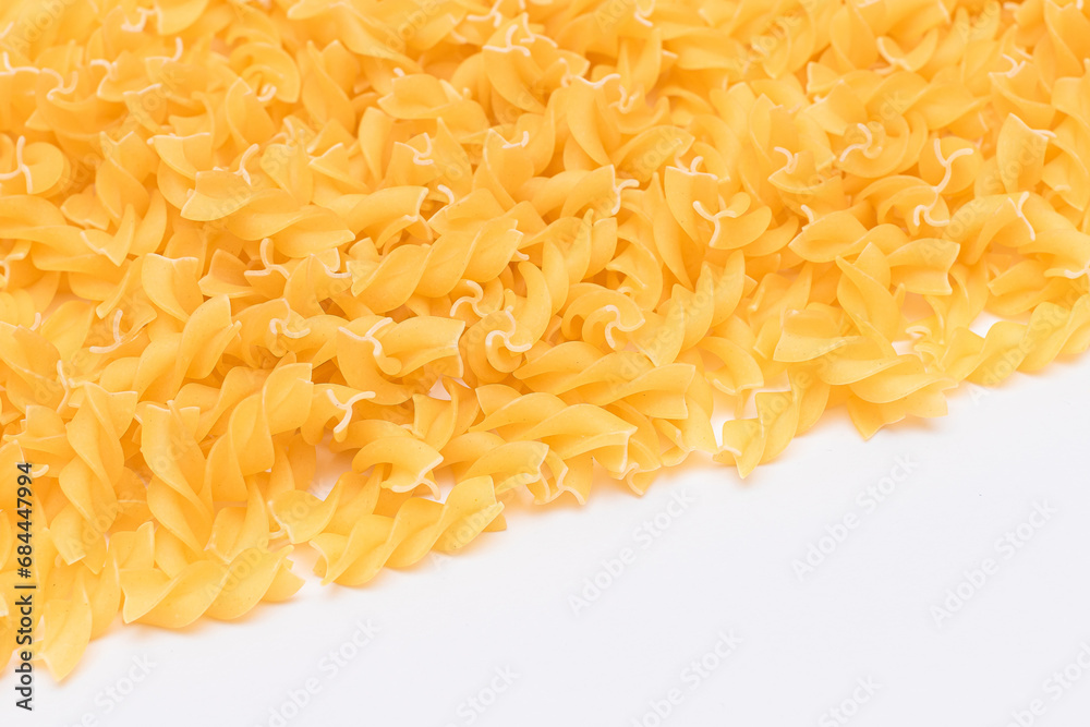 Uncooked Fusilli Pasta with Copy Space on White Background. Raw and Dry Macaroni. Fat and Unhealthy Food - Flat Lay Uncooked Fusilli Pasta with Copy Space on White Background. Raw and Dry Macaroni. Fat and Unhealthy Food - Flat Lay