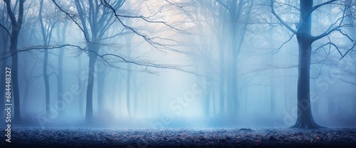 A tranquil scene of a misty blue forest at dawn, with soft light filtering through the trees.