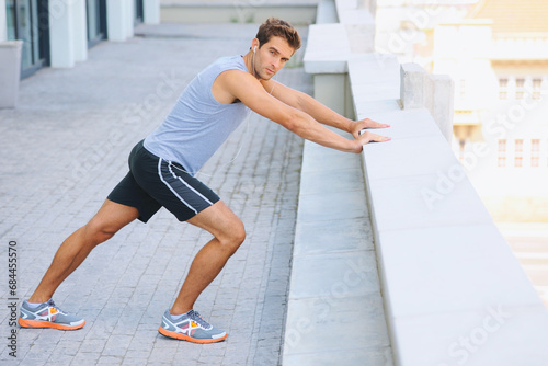 Fotografie Man, portrait and stretching body on balcony in city for fitness, workout or outdoor exercise