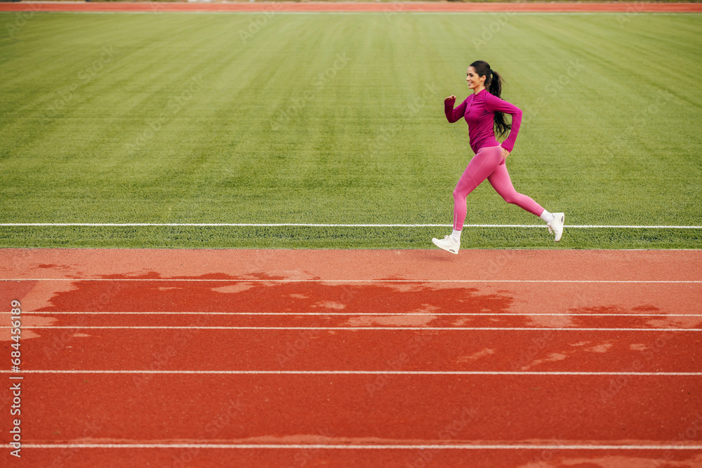 A fit sportswoman running on stadium.