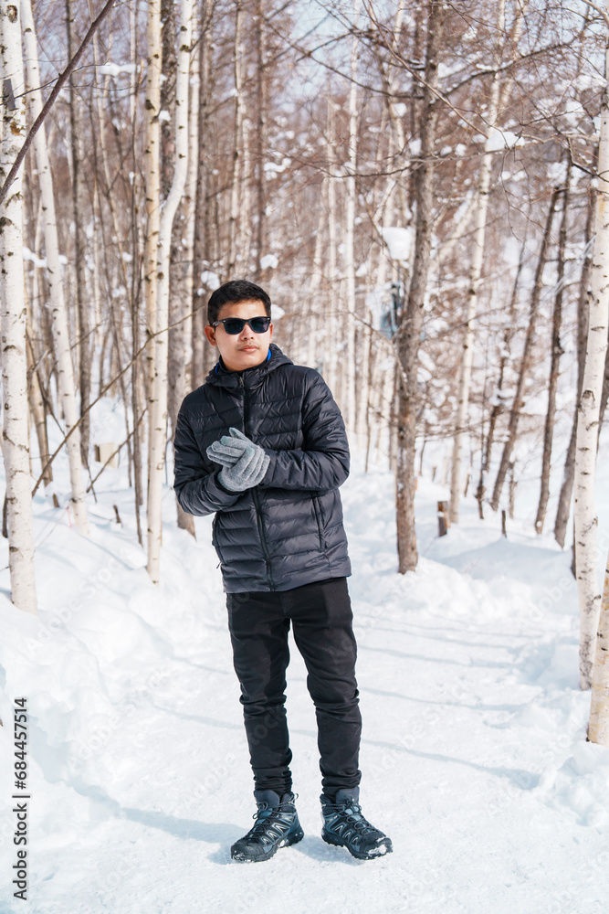 happy Traveler with Sweater walking on snow covered forest in frosty weather. Winter Travel, Adventure, Exploring and Vacation concept