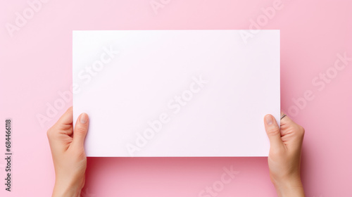 Hand hold a discount card, business card, mockup of a blank white sheet of paper on a pink background with copy space. Template for design. layout. copy space for text.