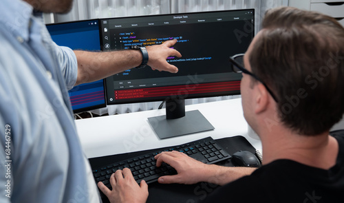 IT developers pointing on software development information on two screens with coding program in application and website. Technical engineer coder analyzing in safety program concept. Sellable.