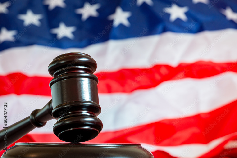 Court hammer, wooden judge gavel over the american flag with copy space