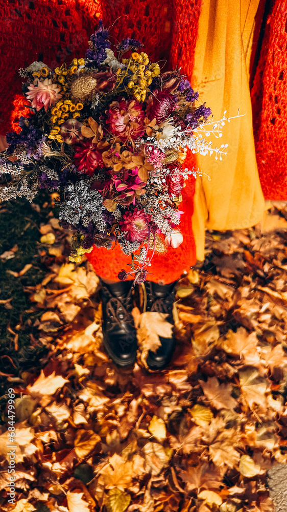 Autumn bouquet on a background of legs and yellow leaves
