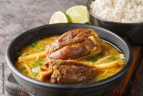 Nihari Pakistani lamb Shank Stew is a traditional slow-cooked one-pot meal made with meat in spicy gravy closeup on the wooden board on the table. Horizontal